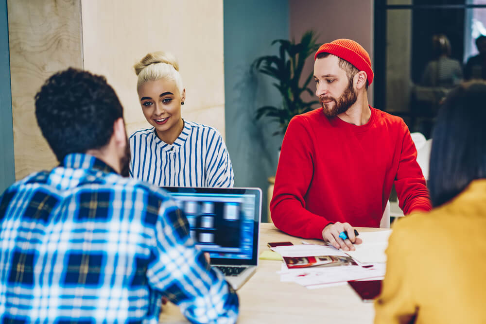 group of employees working on a project with a laptop in front of them